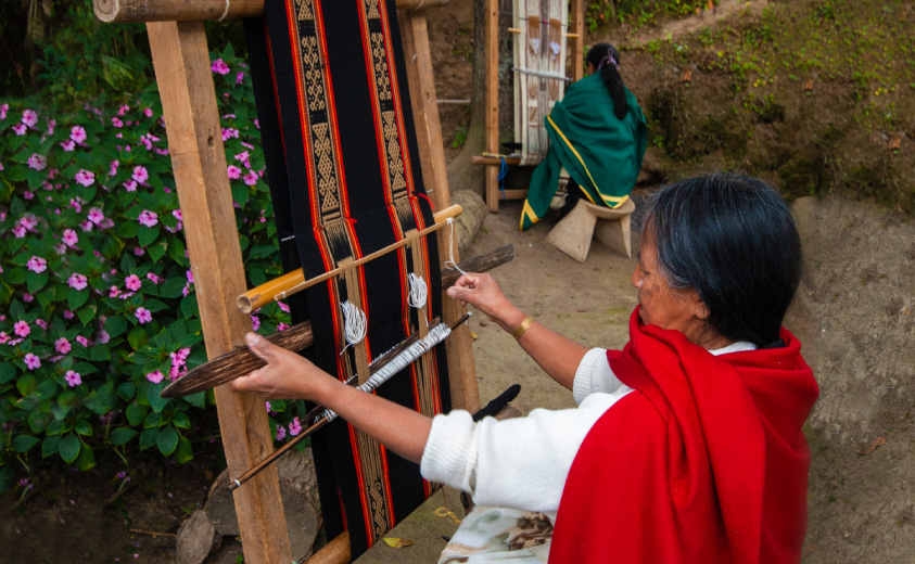 Foto de artesana tejiendo en un telar vertical