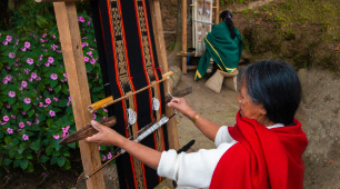 Foto de artesana tejiendo en un telar vertical