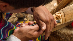 Foto de un artesano tallando una máscara en madera