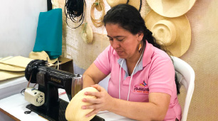 Foto de artesana huilense cosiendo un sombrero