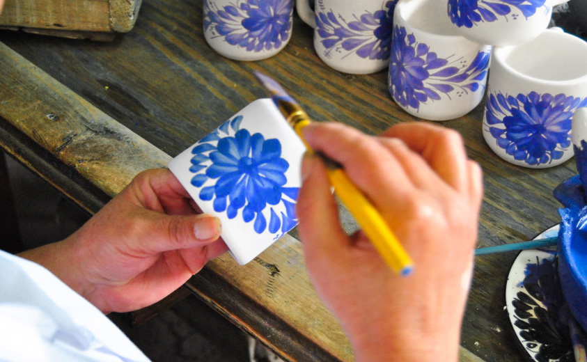 Artesana pintando pieza de cerámica